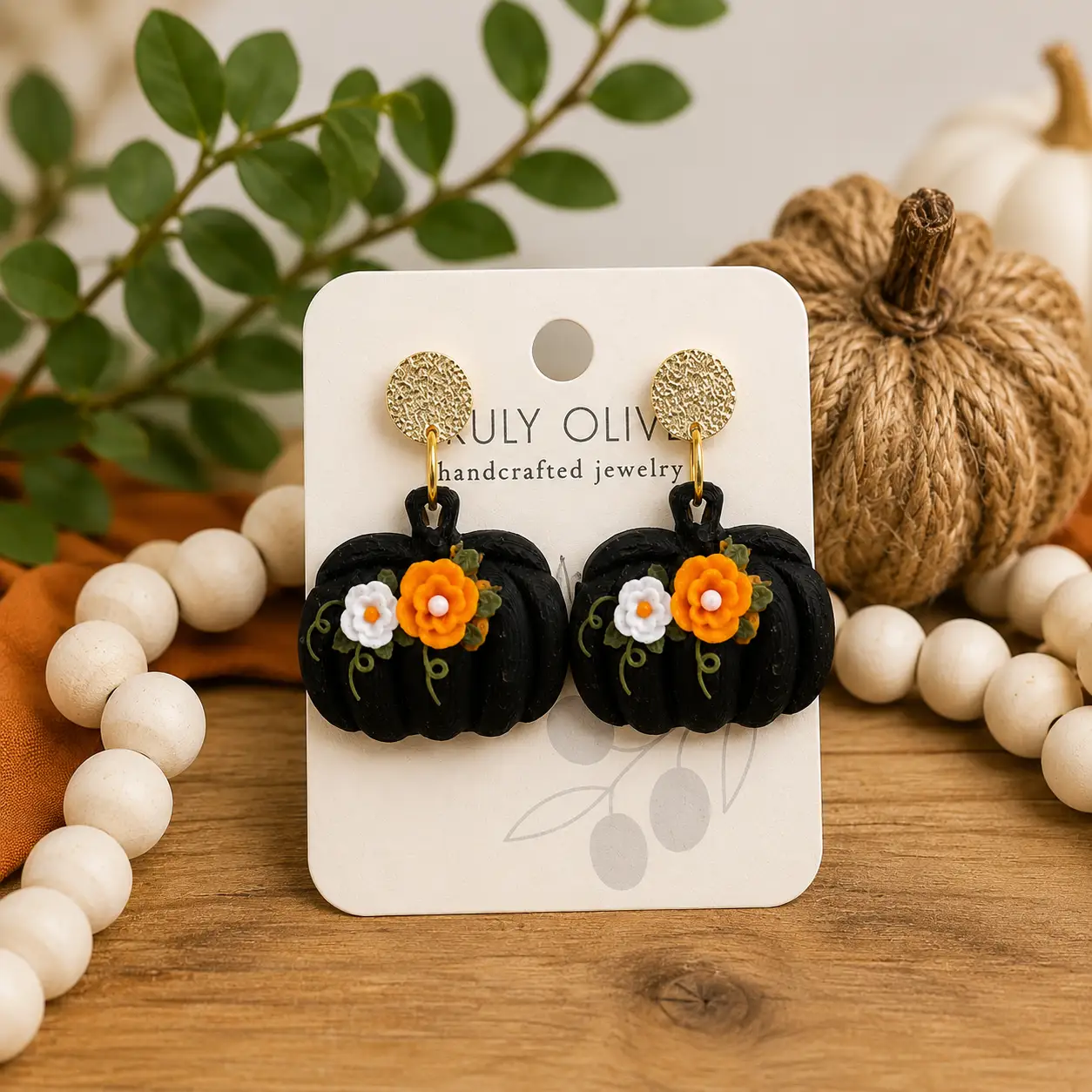 Black pumpkin Halloween earrings styled in a festive autumn setting with pumpkins, fall leaves, and warm seasonal decorations.