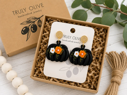 Black pumpkin floral earrings displayed on a Truly Olive jewelry card with boutique-ready packaging for fall or Halloween gifting.