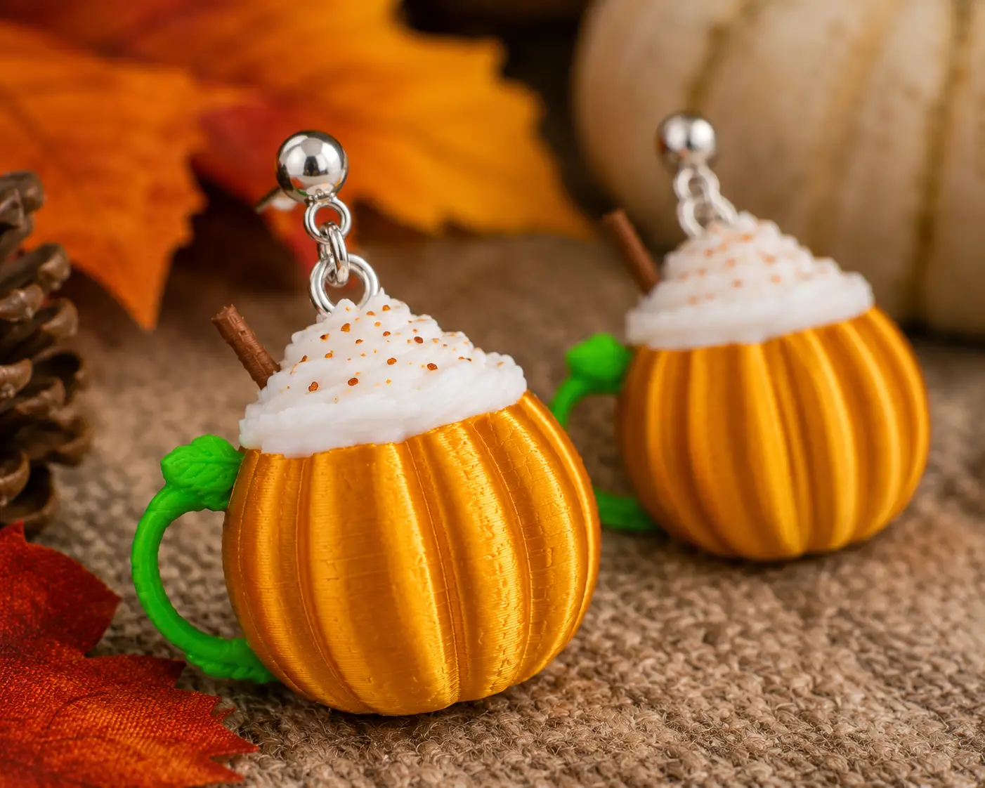 Macro view of handmade pumpkin spice coffee cup earrings showing intricate fall details, lightweight construction, and handcrafted quality by Truly Olive.
