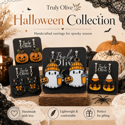 Overhead Halloween flat lay of cozy ghost earrings surrounded by orange pumpkins, black lace, spiderwebs, a decorative skull, and warm seasonal lights.