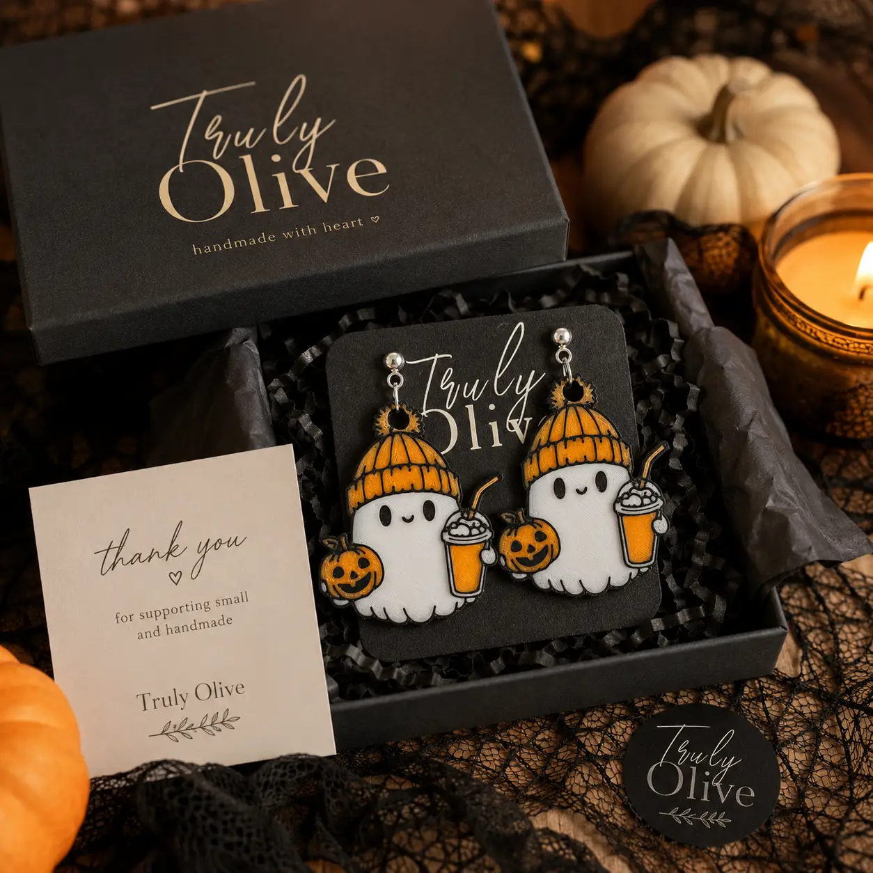 Truly Olive ghost Halloween earrings presented on a branded jewelry card inside gift-ready packaging with orange tissue paper, ribbon, pumpkins, and spooky seasonal accents.
