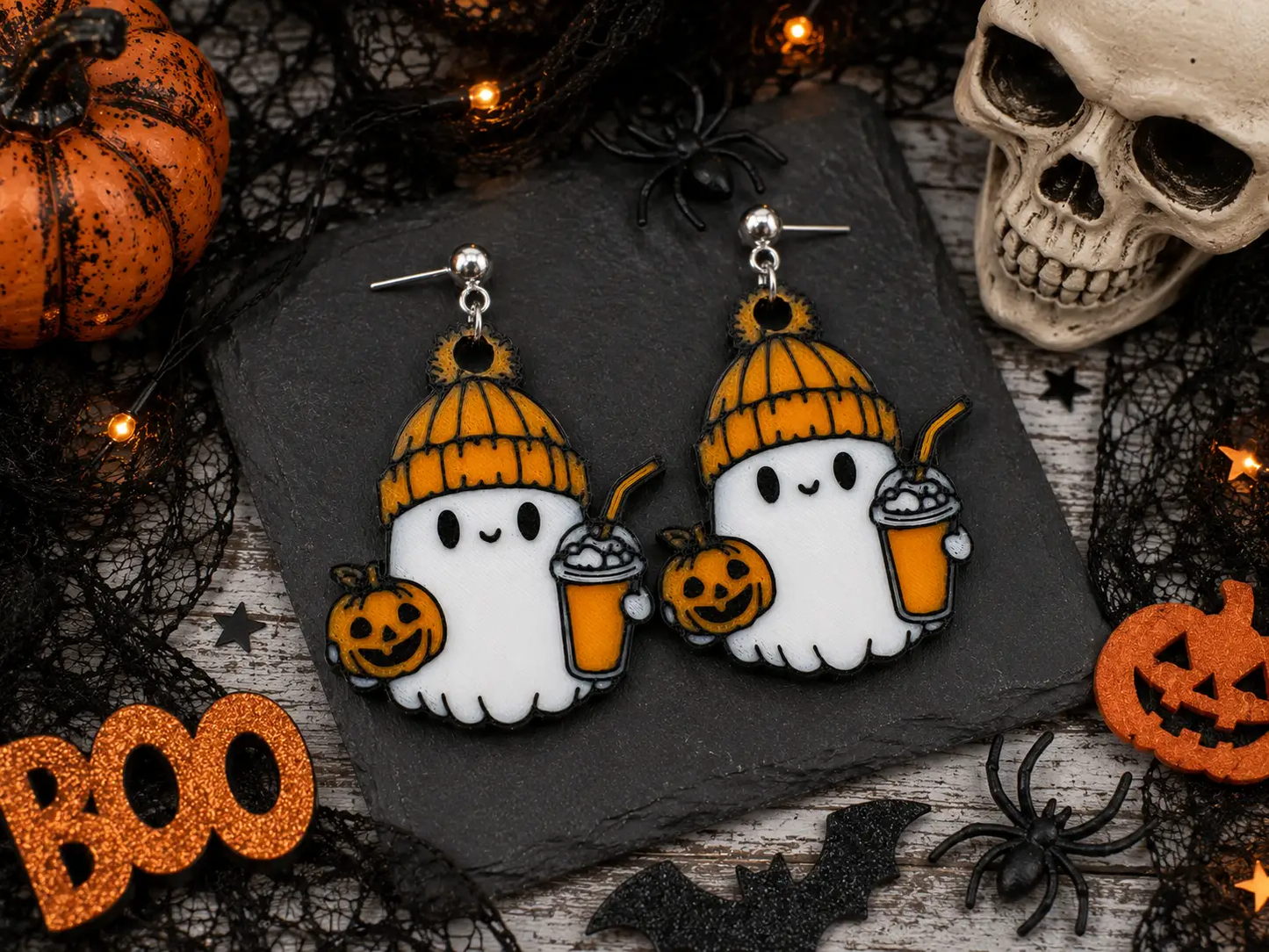 Truly Olive Halloween earring collection featuring cozy ghost, witch hat, pumpkin, and other spooky seasonal designs displayed with pumpkins, candles, and boutique fall décor.