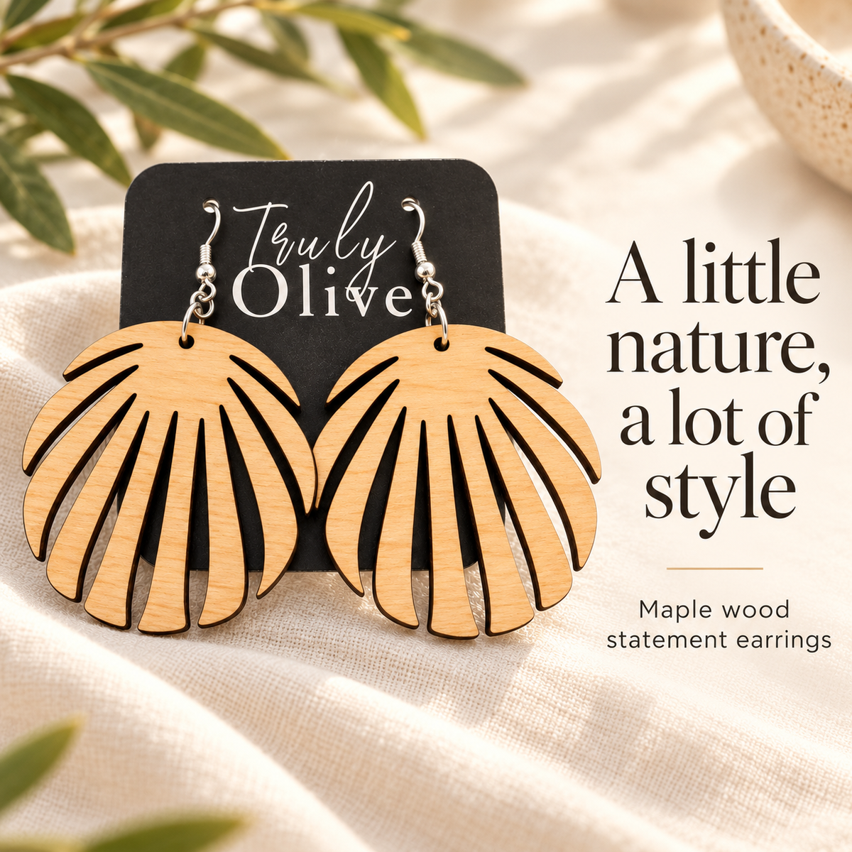 Maple leaf earrings on a Truly Olive card beside the words “A little nature, a lot of style.”