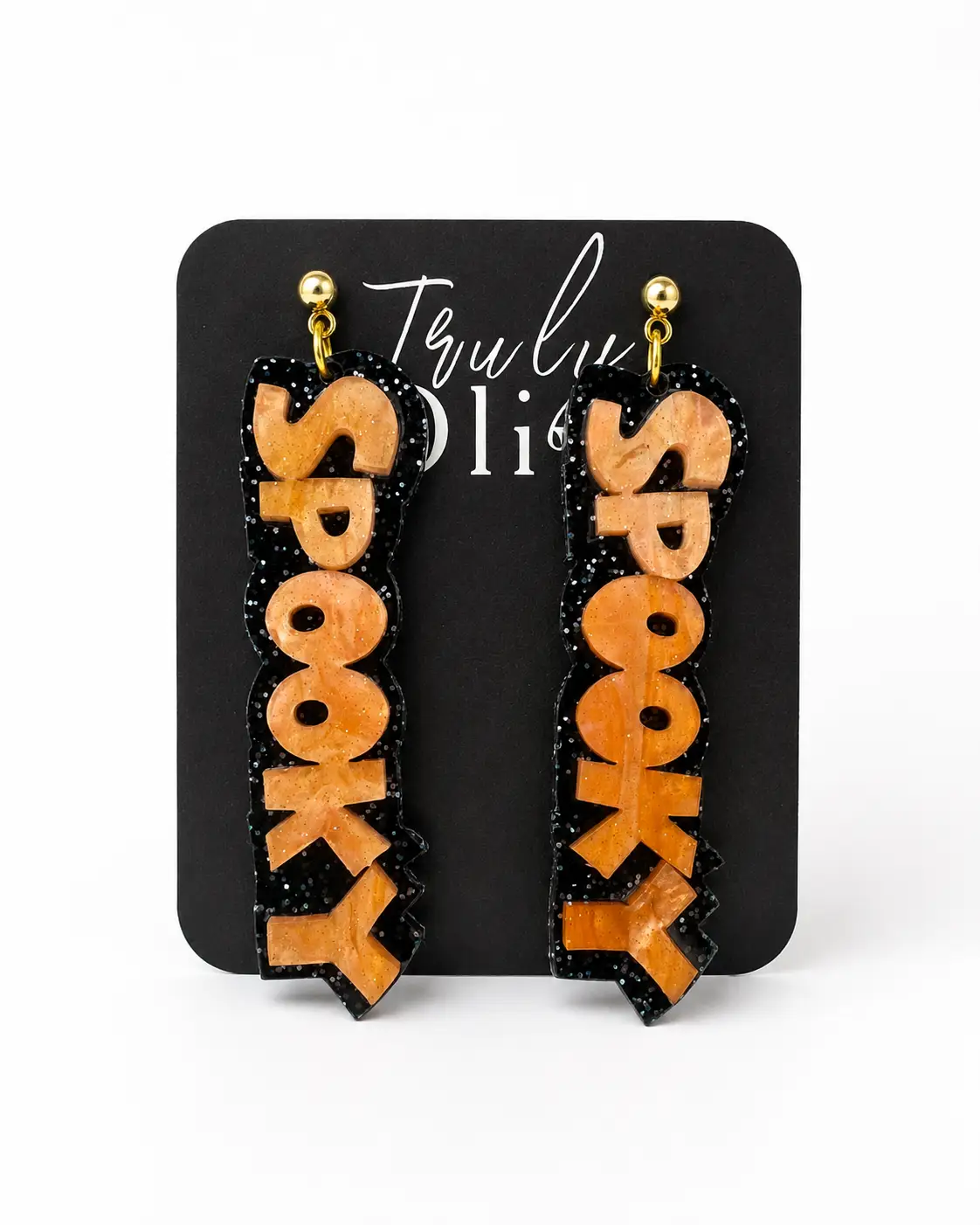 Orange and purple SPOOKY Halloween statement earrings displayed on Truly Olive earring cards with festive pumpkins and boutique fall décor.