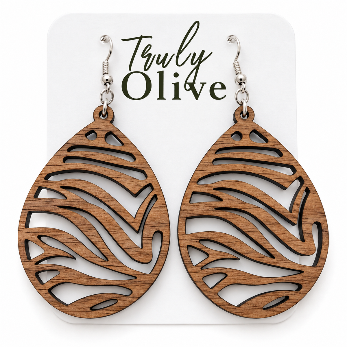 Walnut wood teardrop earrings with darker grain and sweeping zebra cutouts on a white Truly Olive card.