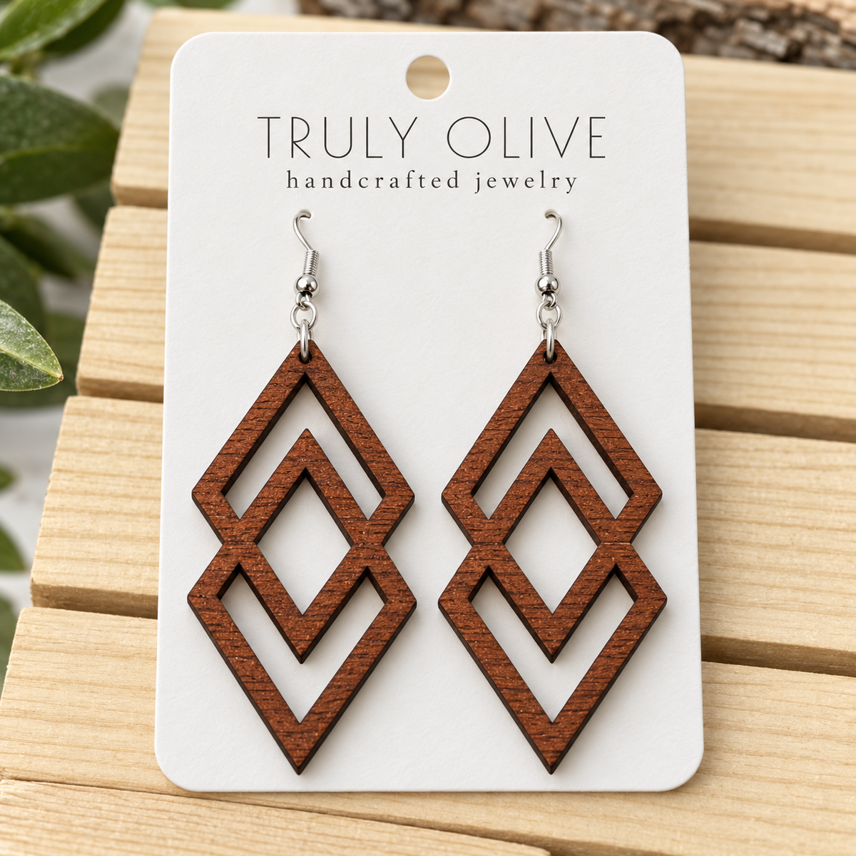 Close view of Sapele Connected Diamond wood earrings showing the wood grain and cutout pattern on a white Truly Olive card.