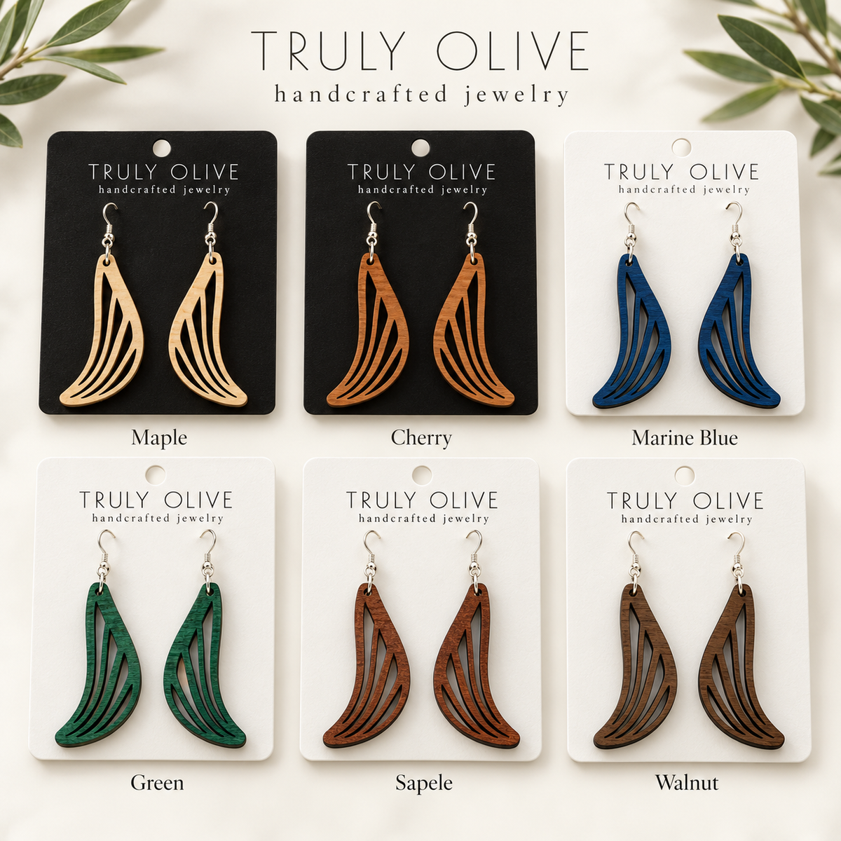 Swept Wing wood earrings shown in Maple, Cherry, Marine Blue, Green, Sapele, and Walnut stains on Truly Olive cards.