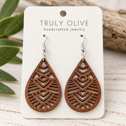 Close view of Sapele Geometric Teardrop wood earrings showing the wood grain and cutout pattern on a white Truly Olive card.