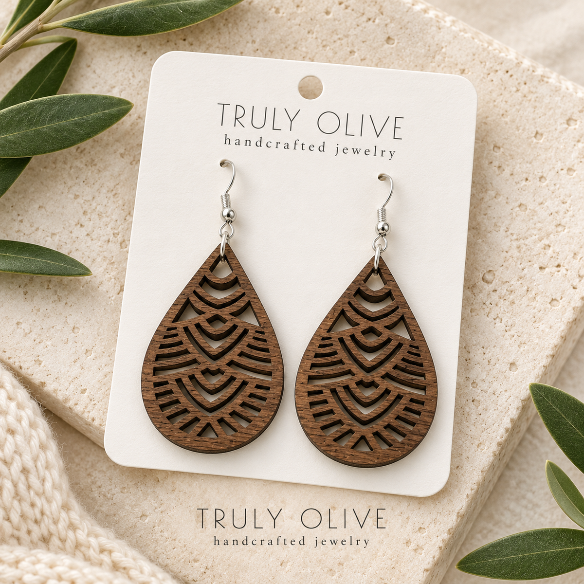 Walnut Geometric Teardrop wood earrings arranged flat with Truly Olive branding.
