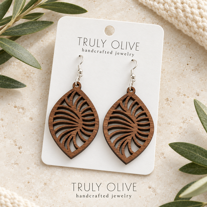 Walnut Spiral Leaf wood earrings arranged flat with Truly Olive branding.