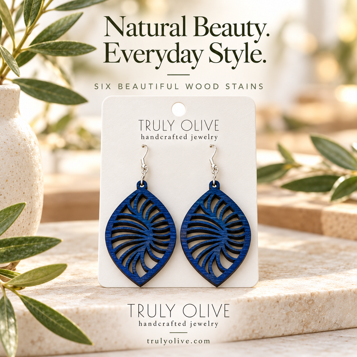 Marine Blue Spiral Leaf wood earrings in a styled product image with Truly Olive branding.