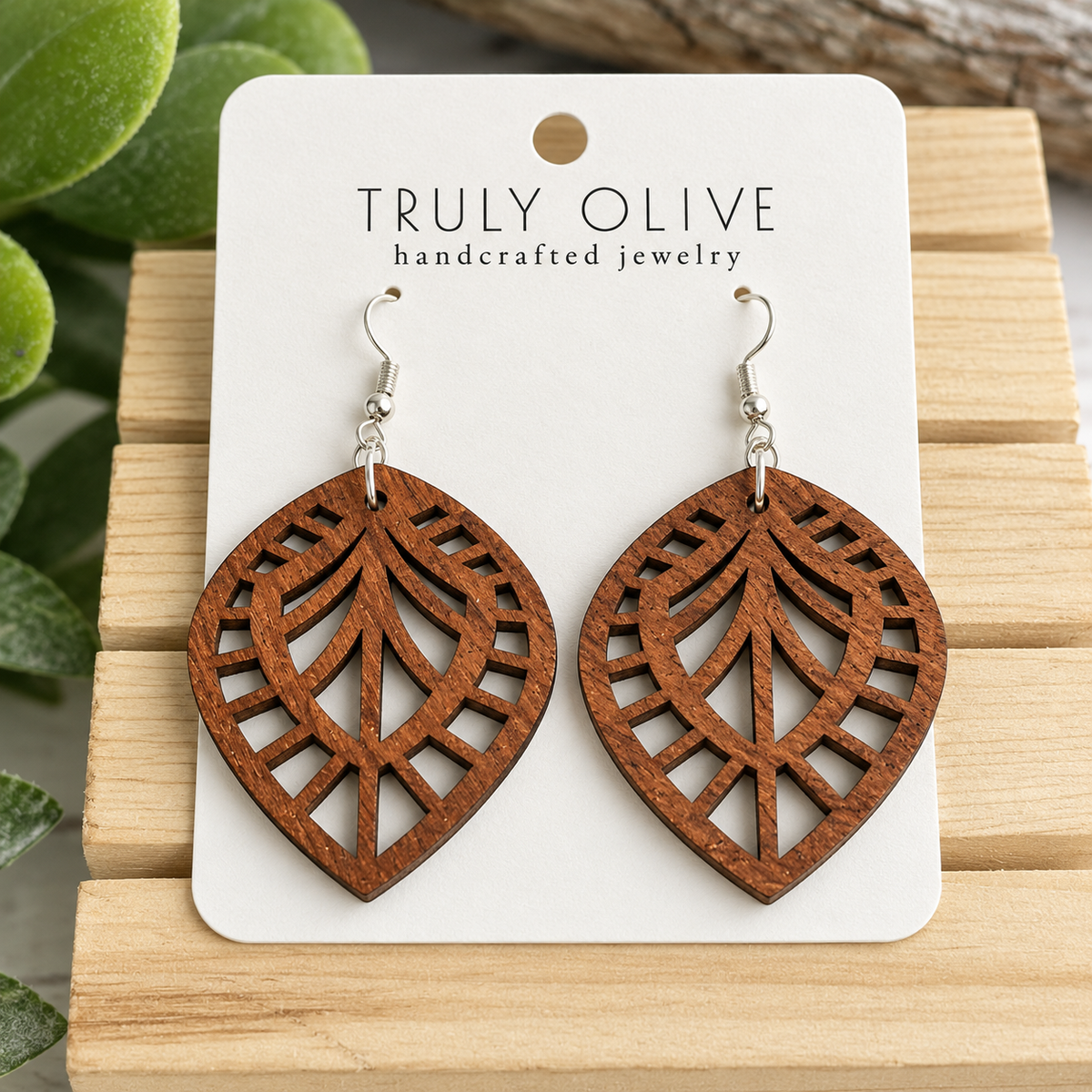 Close view of Sapele Leaf Lattice wood earrings showing the wood grain and cutout pattern on a white Truly Olive card.