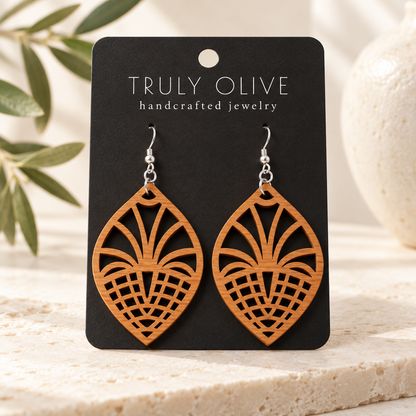 Fan Lattice wood earrings in Cherry stain on a black Truly Olive card in a softly lit styled setting.