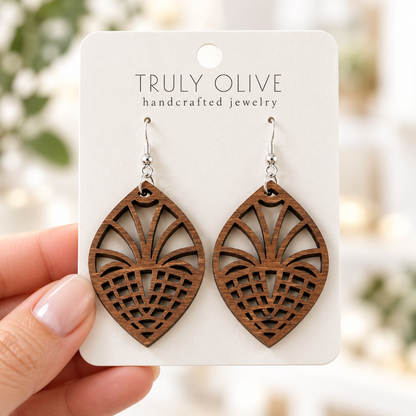 Hand holding a white Truly Olive card with Walnut Fan Lattice wood earrings.