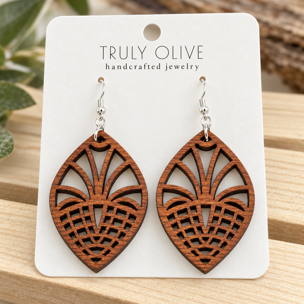 Close view of Sapele Fan Lattice wood earrings showing the wood grain and cutout pattern on a white Truly Olive card.