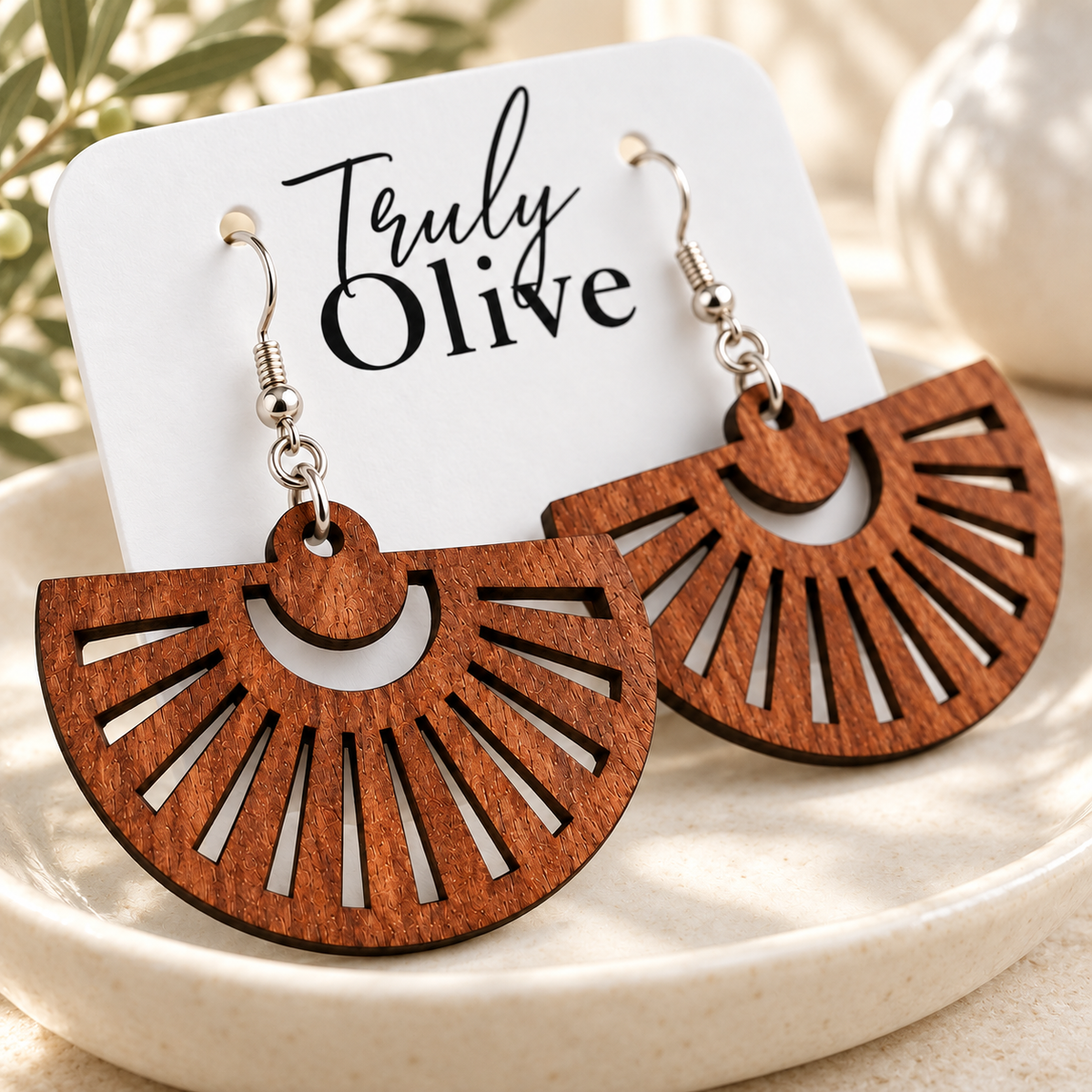 Close-up of Sapele fan earrings showing grain, radial cutouts, and silver hooks.