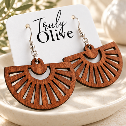 Close-up of Sapele fan earrings showing grain, radial cutouts, and silver hooks.