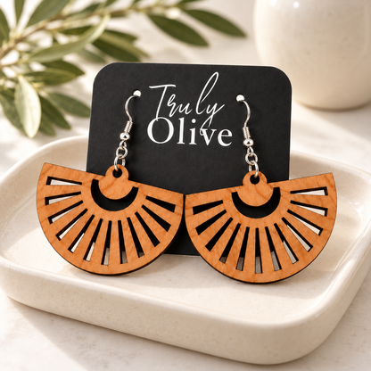 Cherry fan earrings on a black Truly Olive card, styled on an ivory tray with olive greenery.