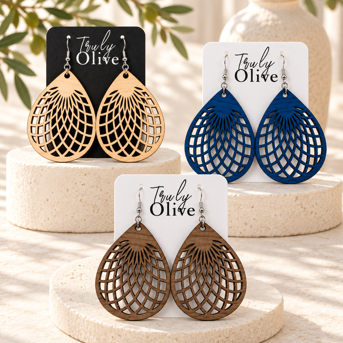 Maple, Marine Blue, and Walnut teardrop earring pairs on ivory displays.