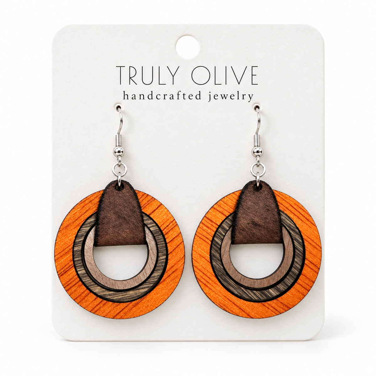 Orange layered wood hoop earrings with neutral brown inner hoops and silver-tone hooks on a white Truly Olive card.