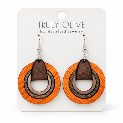 Orange layered wood hoop earrings with neutral brown inner hoops and silver-tone hooks on a white Truly Olive card.